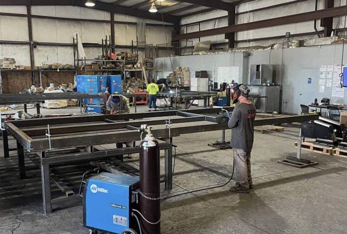 Workers fabricating steel structures indoors